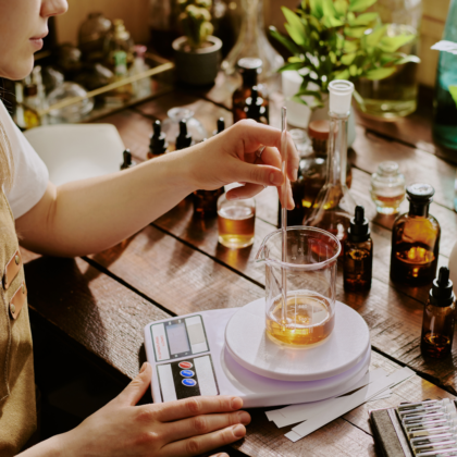 Une personne en tablier utilise une balance pour mesurer la quantité de liquide dans un verre