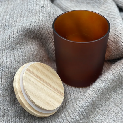 Pots en verre à côté d'un couvercle en bois sur fond en tissu