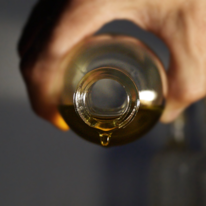 une bouteille d'huile d'olive versée dans un verre