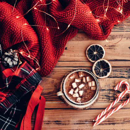 chocolat chaud avec des guimauves et des cannes de bonbon sur une table en bois
